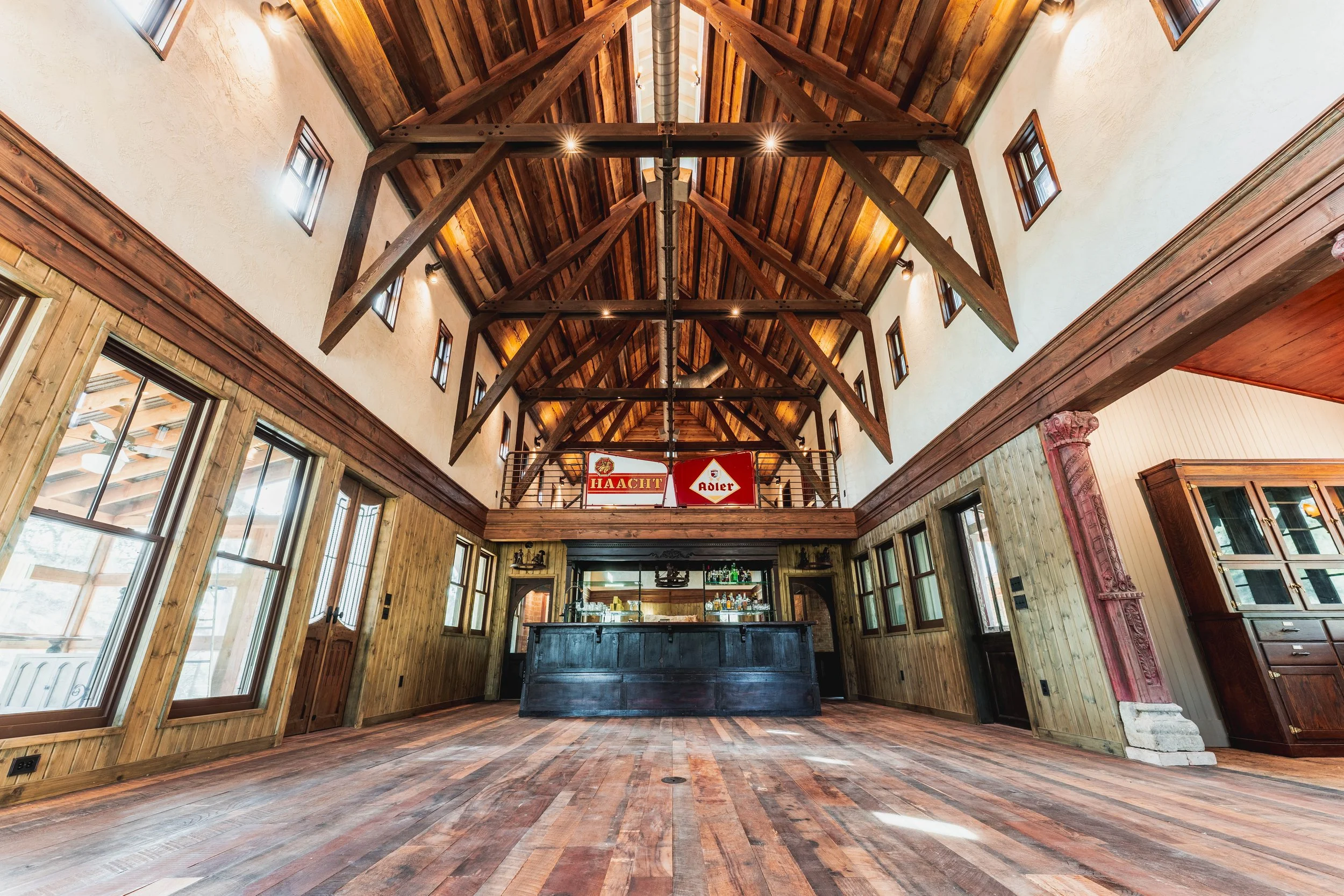 H2 Lodge stone fireplace beneath a timber ceiling